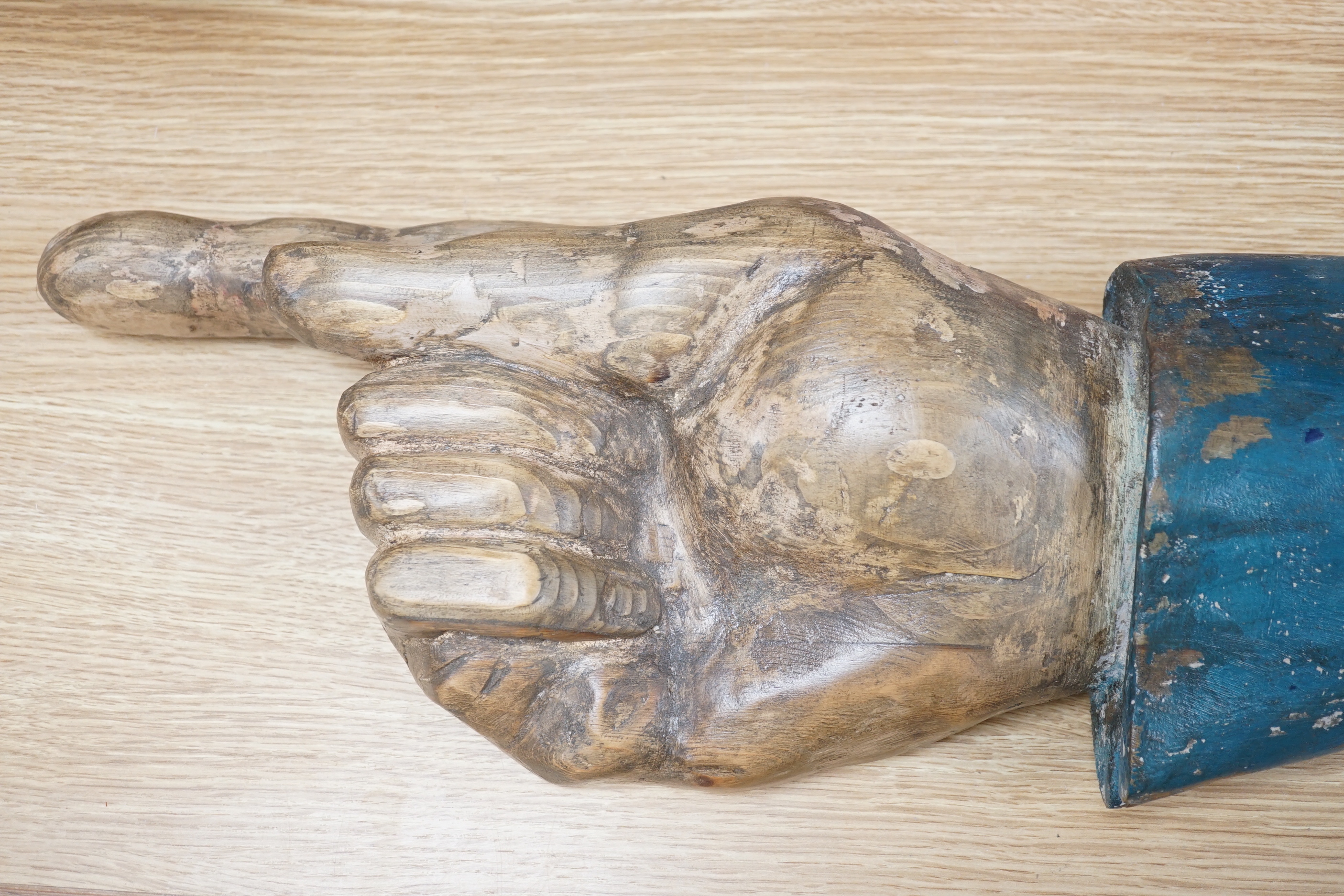 A carved wood and painted pointing forearm, 65cm wide